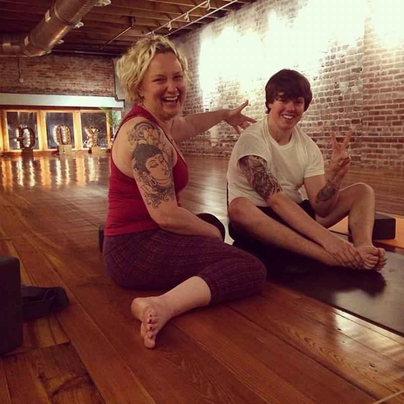 Matt stretching with yoga instructor and giving peace sign