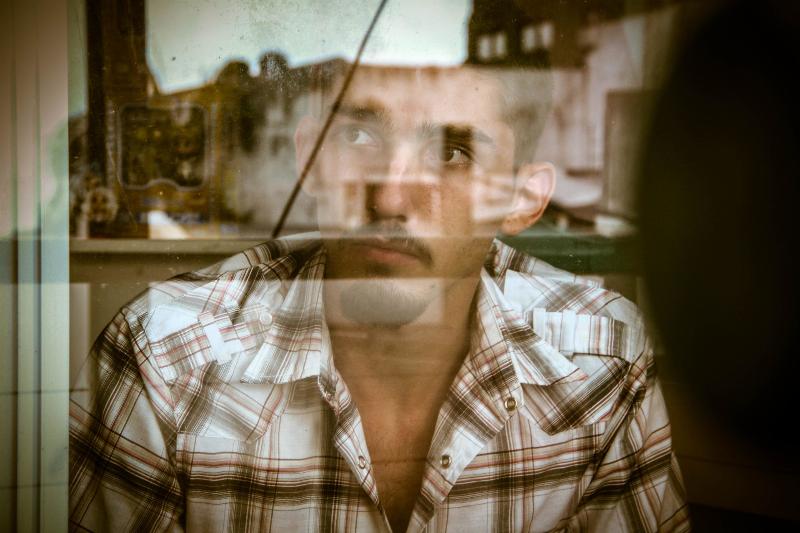 man stands in front of window reflection