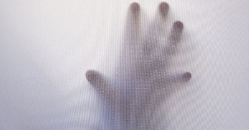 hand reaching out behind white light