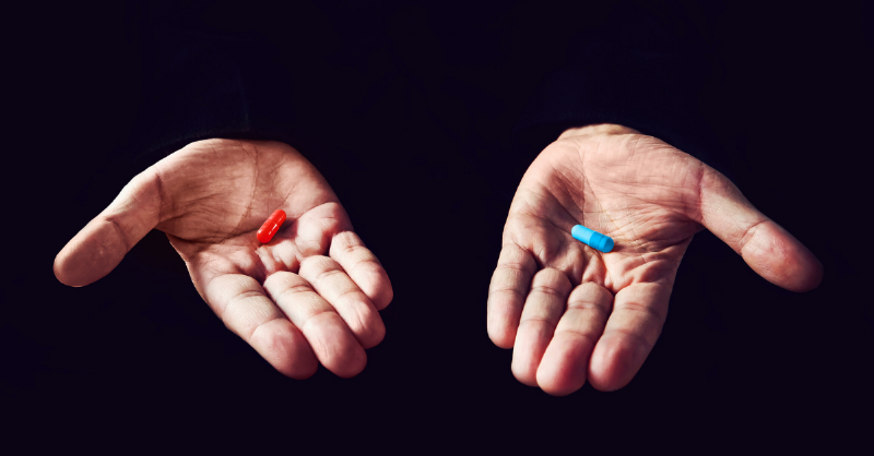 hand holding red pill or blue pill