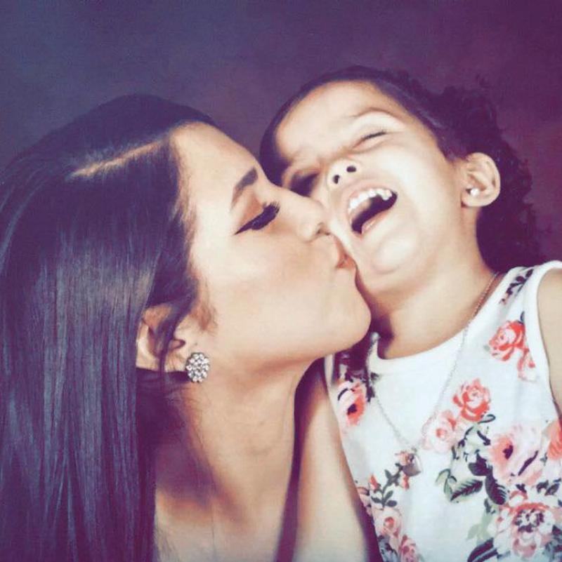 Sandra kisses her daughter on the cheek