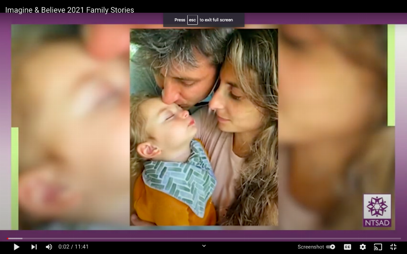 mom and dad hold baby and kiss her forehead