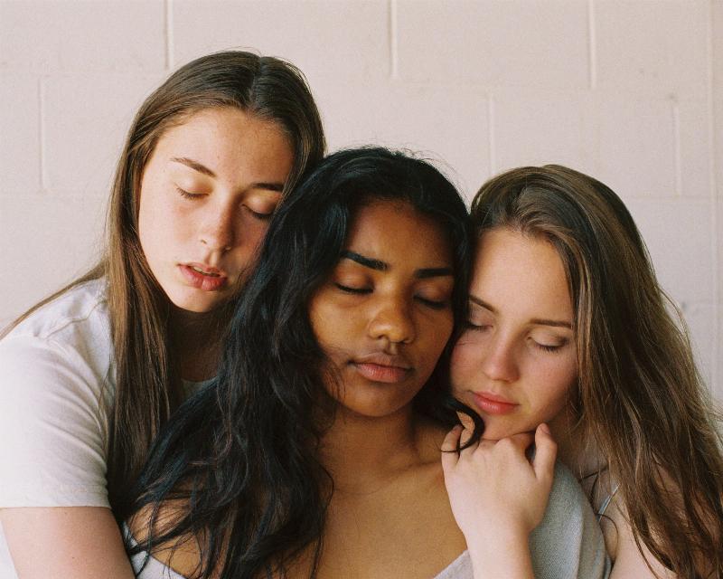 three women with eyes closed