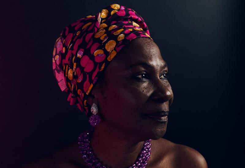 African Woman in head scarf and purple jewellery close up smiling