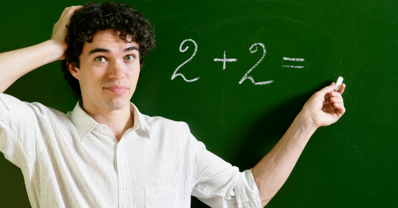 man looks confused in front of 2+2= equation on blackboard
