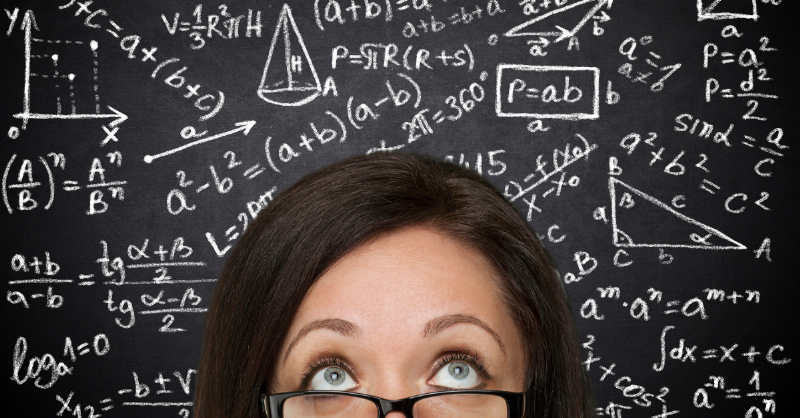 cut off face of woman with glasses in front of blackboard full of equations