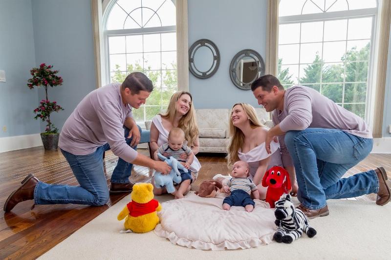 both twin families playing with babies on the floor