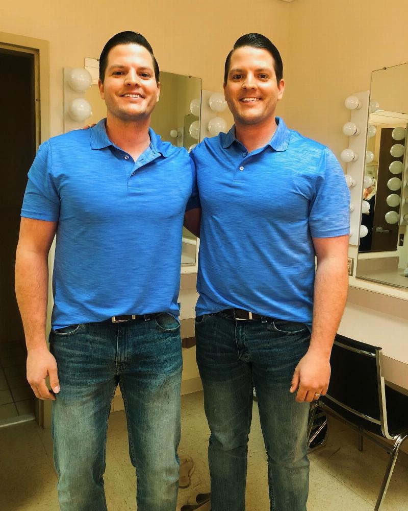 twin brothers posing with their arms wrapped around one another in mtaching blue polos