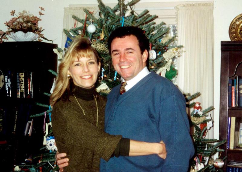 Beverly hugs Sean by christmas tree