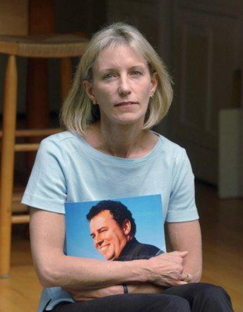 Beverly (older) holds sean's picture close as she sits down