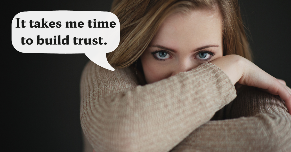 woman wrapping her arms around her legs with her face peaking out and speech bubble that says 