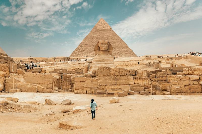 man walking in desert  in Egypt by pyramids