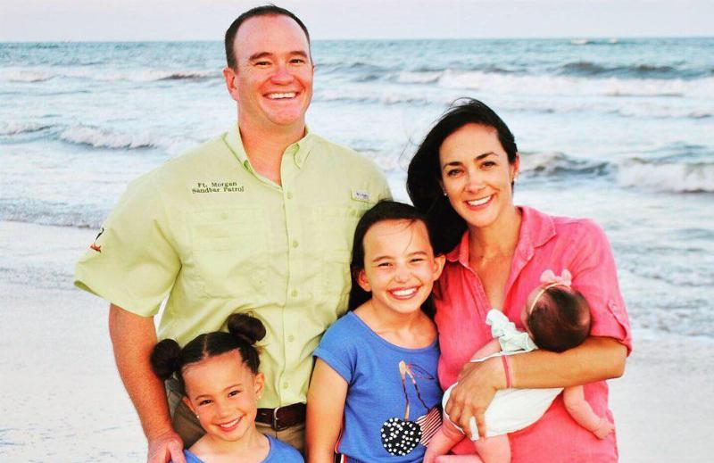 Nicole , her husband, her daughters and a newborn by the beach