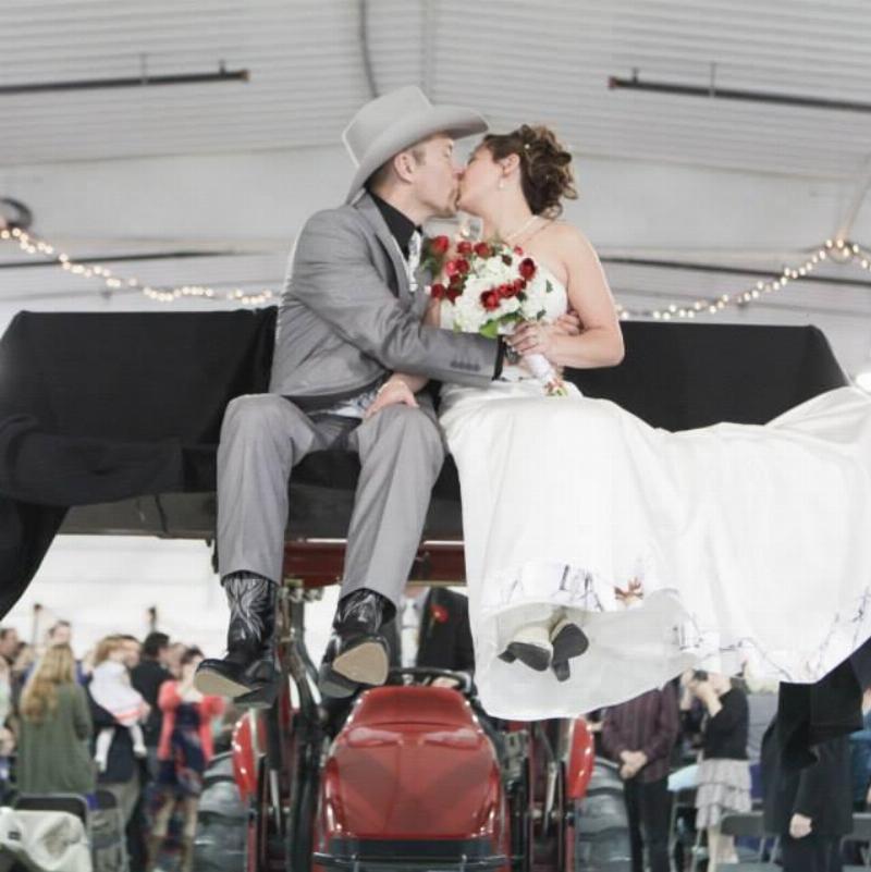 bride and groom kissing above car