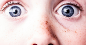 scared blue eyes close up on face with freckles
