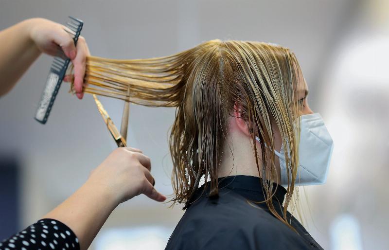 hairdresser cutting blonde woma's hair