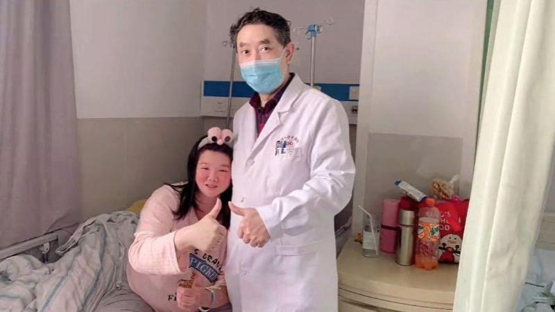 Liu and doctor pose at hospital bed