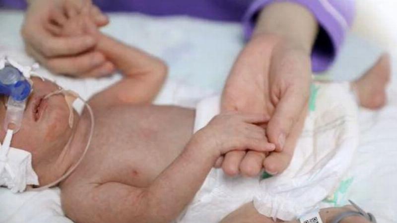 newborn baby holding adult hand