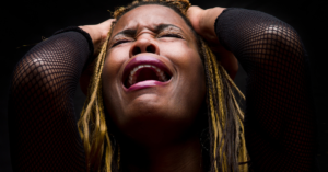 woman screaming and crying holding her head