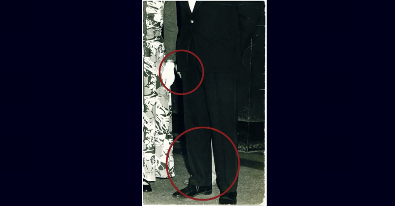 ghost figure's legs ad hand circled behind the man in the suit