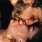 man leans down to kiss woman