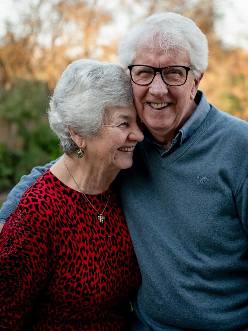 older couple poses for picture smiling