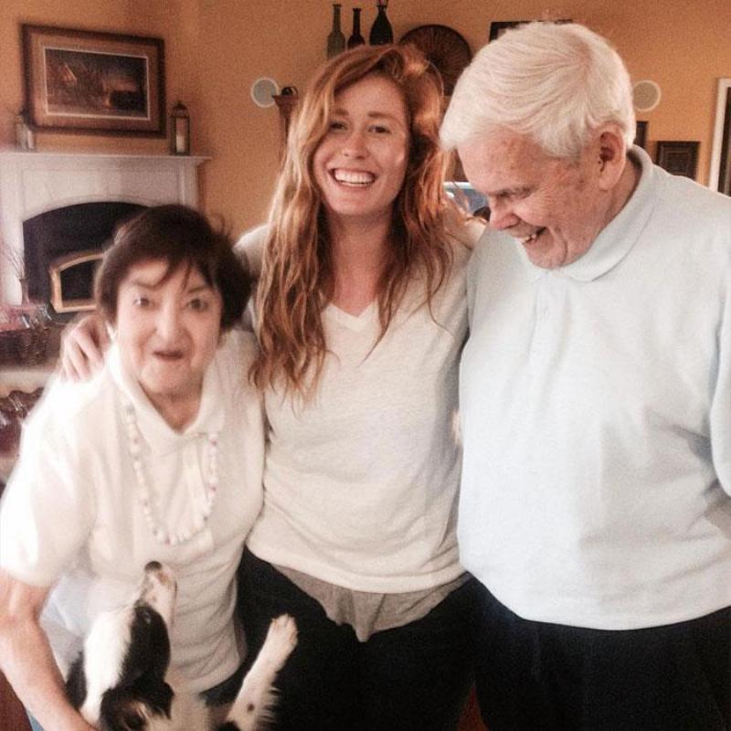 Elizabeth smiles in a picture surrounded by her grandparents and the dog