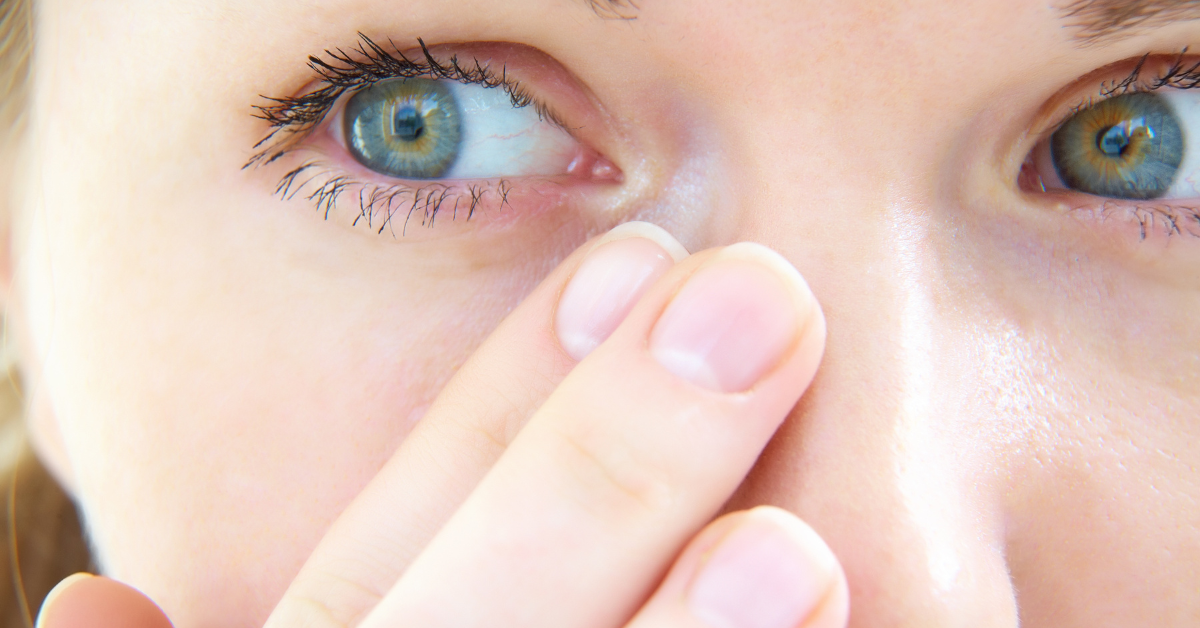 finger wipes tear from blue eyes