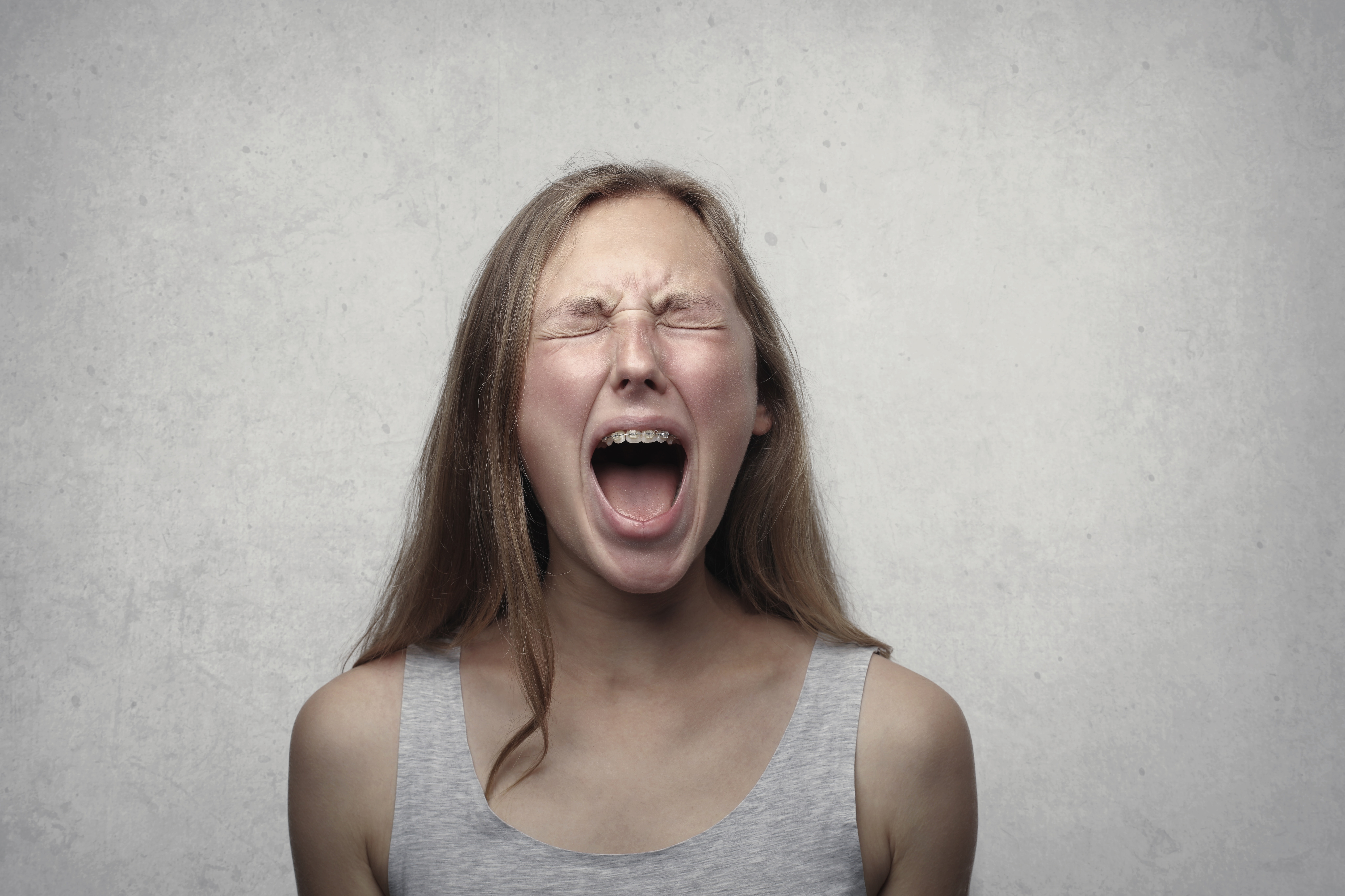 woman screaming with eyes closed